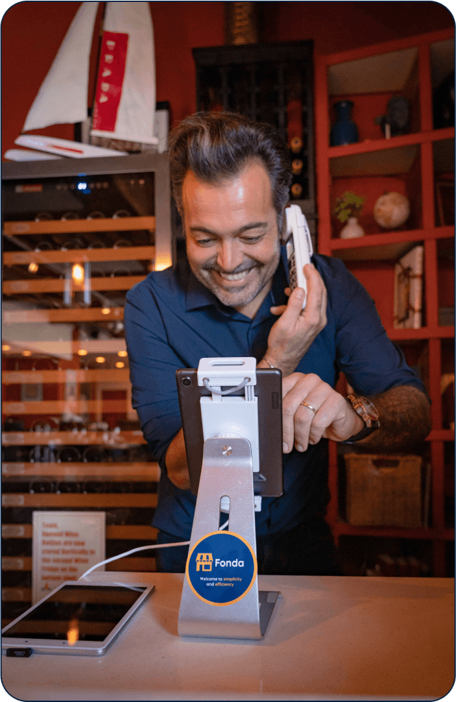 A smiling restaurant owner using a tablet point-of-sale system